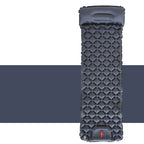 Black inflatable camping mattress with pillow and quilted surface on white and dark background